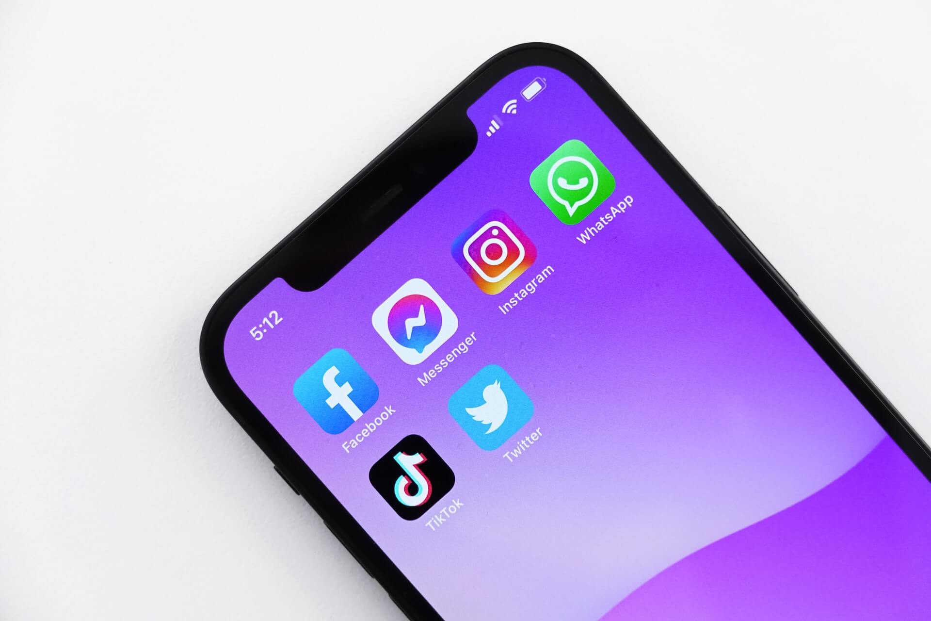 En telefon med lila bakgrund som visar sex appar. Varav fem appar inom sociala medier som man gör att man kan tjäna pengar 2022.